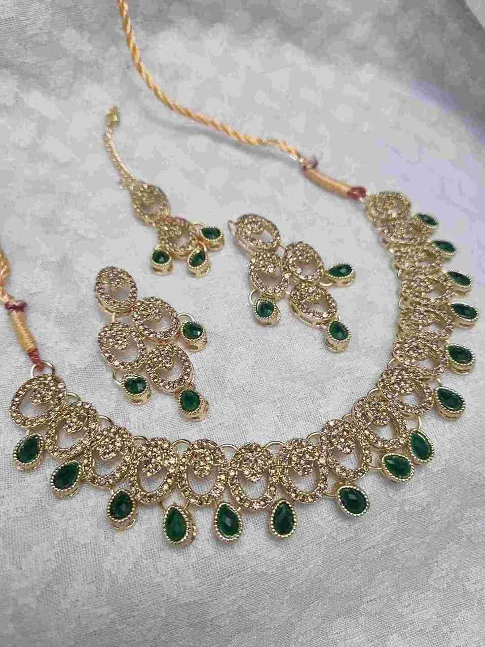 Elegant gold necklace set with green drop accents and matching earrings.