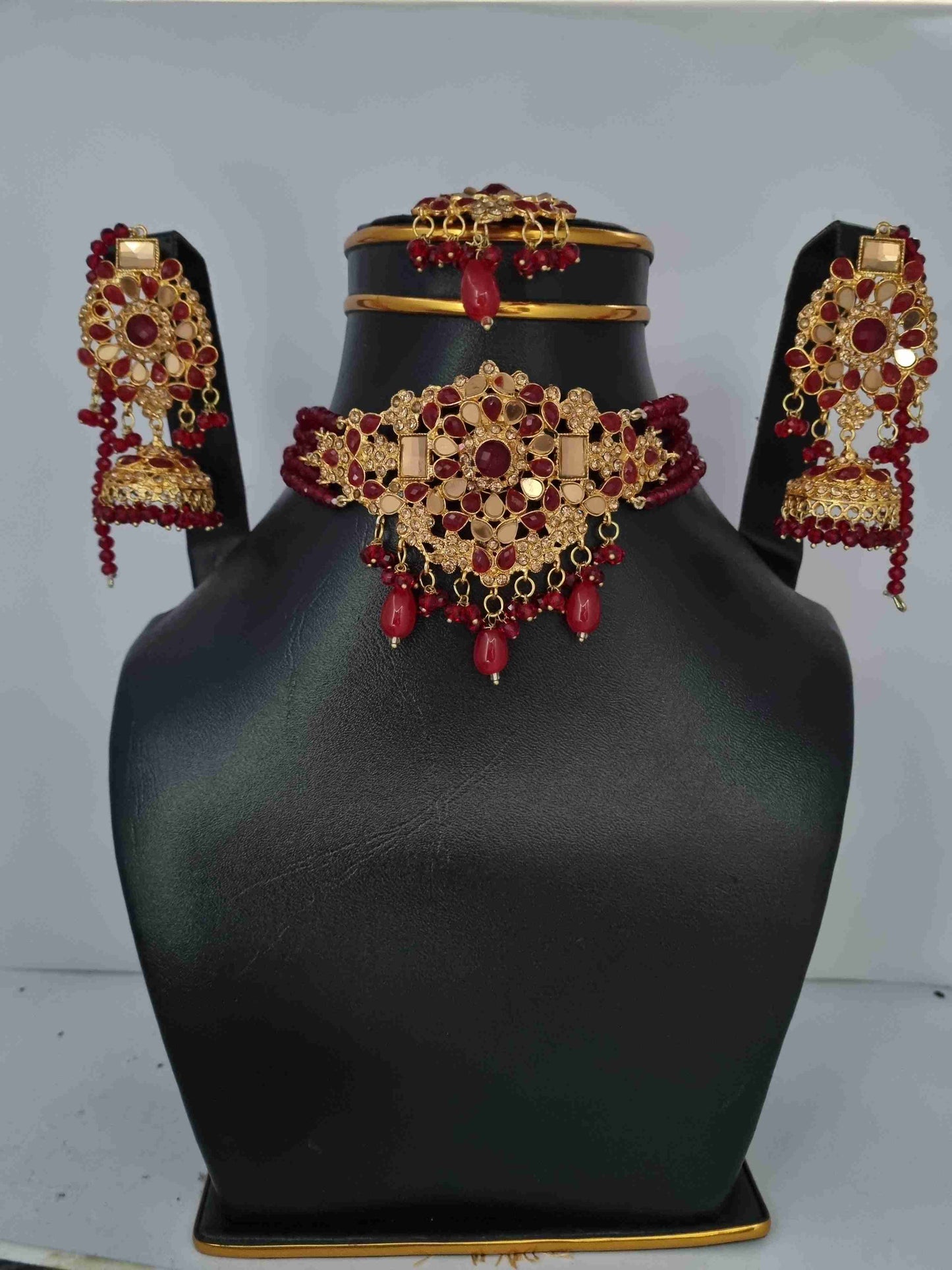 Gold and red Kundan bridal jewelry set with earrings, Jhumkas, and a choker necklace.0