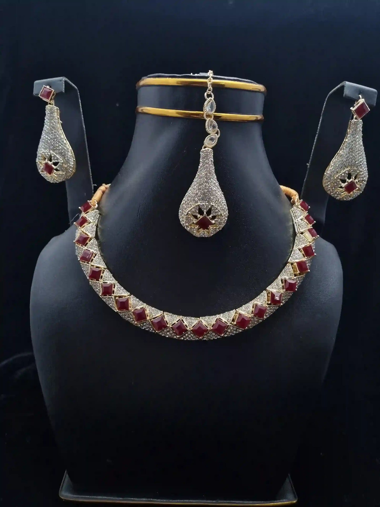 Ruby bridal necklace set featuring a stunning necklace and matching earrings with intricate gold and silver details.